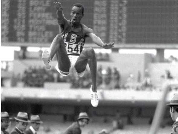 18 Oct 1968: Bob Beamon #254 of the USA breaking the Long Jump World Record during the 1968 Olympic Games in Mexico City, Mexico. Beamon long jumped 8.9 m (29 ft 2 1/2 in), winning the gold medal and setting a new world record. It is the first jump over 28 ft. The most famous long jump ever achieved: Bob Beamon of the United States takes off for a place in sporting history as he leaps 8.90 metres at the Mexico City Games of 1968.  While the middle distance runners from the low level countries floundered in the thin air of Mexico City, those in the explosive events reached new peaks, none higher than Beamon, who added 58 centimetres to the world record with a jump aided by a wind of 2 metres per second the very limit of wind assistance.  In Imperial measure terms it looked even more impressive since he missed out 28 feet, taking the record to 29 ft 2 ins.  Yet Beamon never again managed a jump of 27 feet.  It was twelve years before anyone else reached 28 feet (8.53 metres) and the record stood until 1991 when Mike Powell of the US leapt 8.95 metres in Tokyo to win the world title.  His jump was at sea level and wind assistance of 0.3mps. Mandatory Credit: Tony Duffy  /Allsport